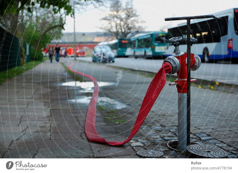 After the fire has been extinguished, the fire hose lies limp and without water on the ground. Fire department Fireman Fire engine Firefighters