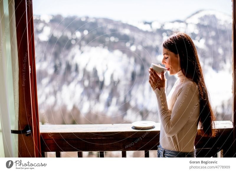 Young woman with cup of hot tea in winter window morning breakfast lifestyle young relax people home smile beautiful female dreaming attractive drink cute