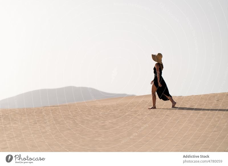 Traveler walking in desert at sunset tourist stroll hill sky explore wanderlust nature woman landscape traveler vacation trip island spain corralejo dune