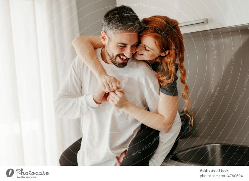 Happy couple hugging while spending time together in balcony at