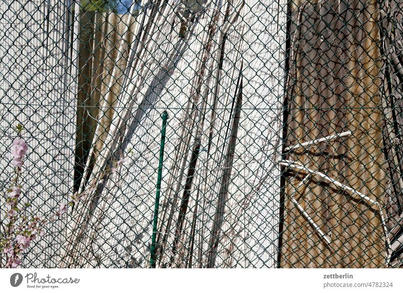 Chain link fence in desolate condition Garden allotment Garden allotments Deserted tranquillity Garden plot Copy Space Depth of field Fence Wire netting