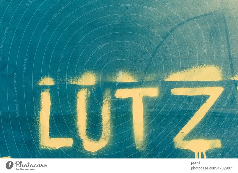 Lutz - a sympathetic first name Name Man Boy (child) Letters (alphabet) Typography Wall (building) Word Congenial Blue Yellow Graffiti writing Spray Characters