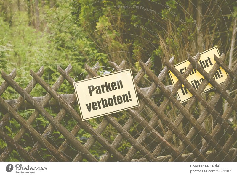 No parking sign on hunter fence with green garden in background no parking Parking Signage Bans Parking lot Signs and labeling Road sign Exterior shot