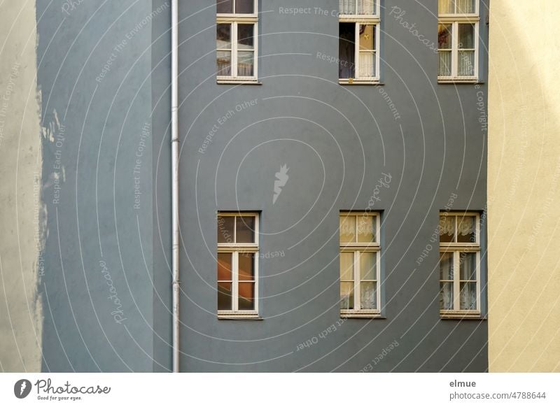 View of gray and blue apartment building lying in the shade / live Apartment house dwell Window Downspout Residential area city apartment rent brake