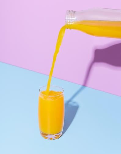 Orange juice glass on a blue table. Pouring orange juice. background beverage bottle breakfast bright citrus close-up color colorful cyan delicious drink drip