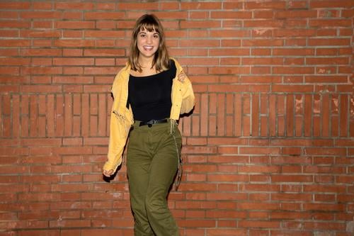 Young woman stands near an old brick wall in the city at night young standing attractive smiling happy casual attire female person beautiful lifestyle