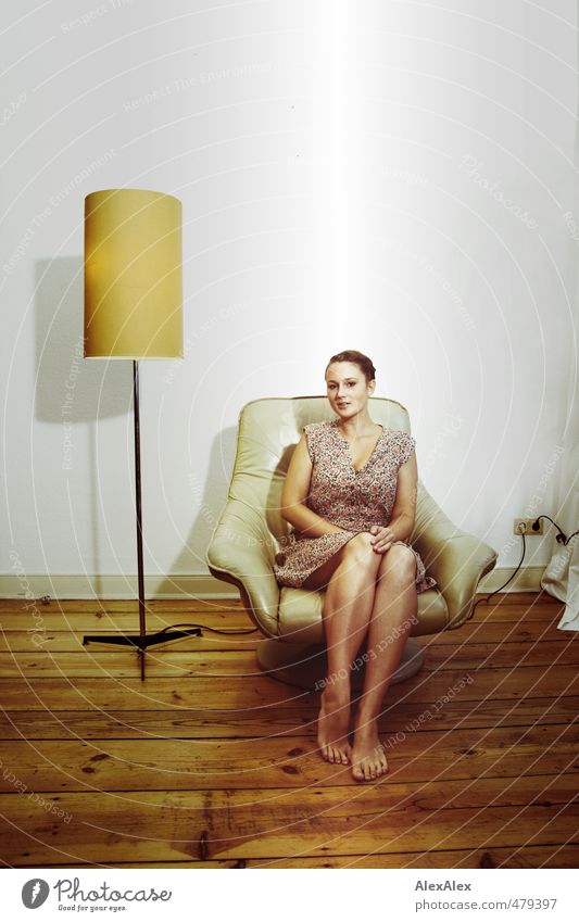 Young barefoot woman in a summer dress sitting in a beige armchair Young woman Youth (Young adults) Legs Feet 18 - 30 years Adults Small room Floorboards