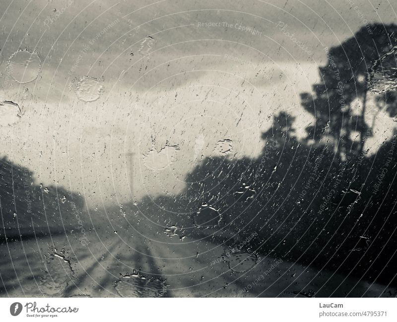 Foul weather on the highway Rain Storm raindrops Highway Wet Bad weather Drops of water Window pane Windscreen Motoring somber Dark Gray grey sky Clouds