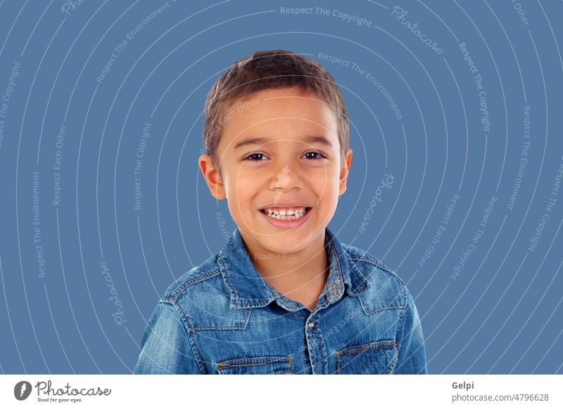 Latin child with denim shirt looking at camera and laughing person boy latin happy isolated childhood cute blue smile male portrait young background adorable