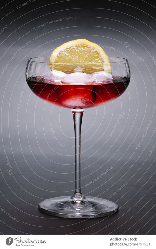 Cocktail with ice and lemon wineglass alcohol beverage cocktail ice cube serve drink aperitif booze citrus fruit decorate sour slice portion transparent cold