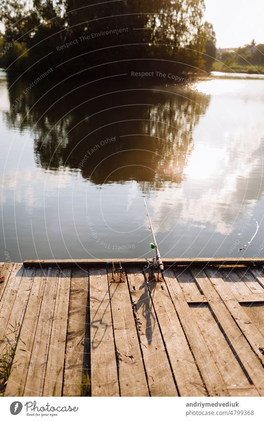 Fisherman with rod, spinning reel on river bank. Fishing for pike