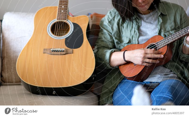 Asian girl playing ukulele Guitar Ukulele asian asian woman Musician Musical instrument guitars Home Sofa Musical instrument string Living room female