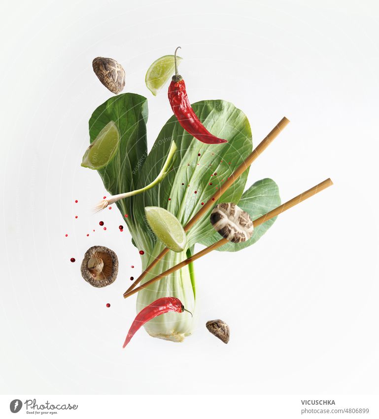 Asian food concept with flying ingredients and chopsticks at white background. Levitation  food. asian food bok choy lime shiitake spices chili levitation food