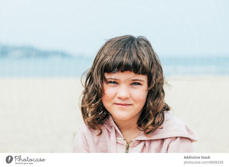 Cute girl resting on beach summer weekend vacation daytime portrait dark hair appearance adorable kid cute coast child childhood relax season blue sky holiday