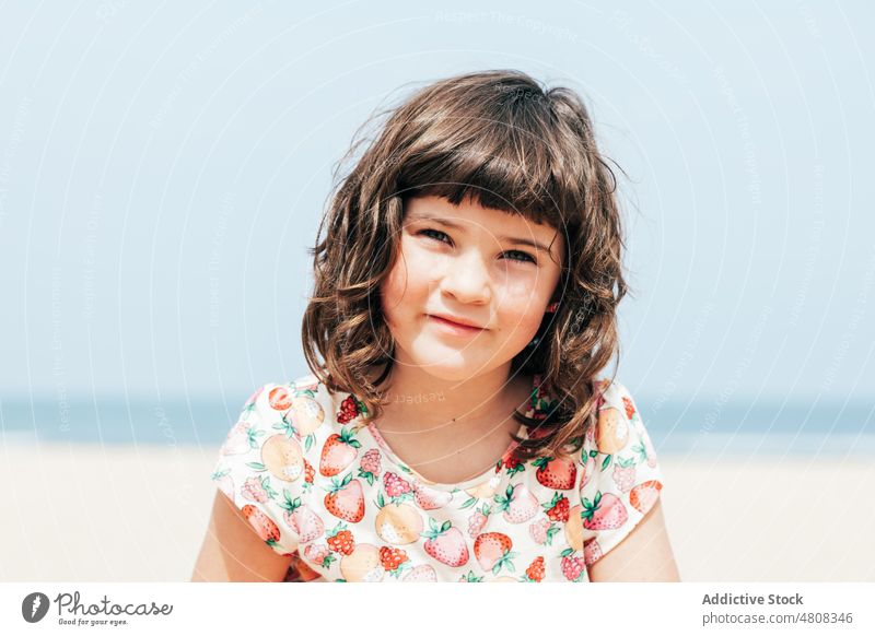 Cute girl resting on beach summer weekend vacation daytime portrait dark hair appearance adorable kid cute coast child childhood relax season blue sky holiday