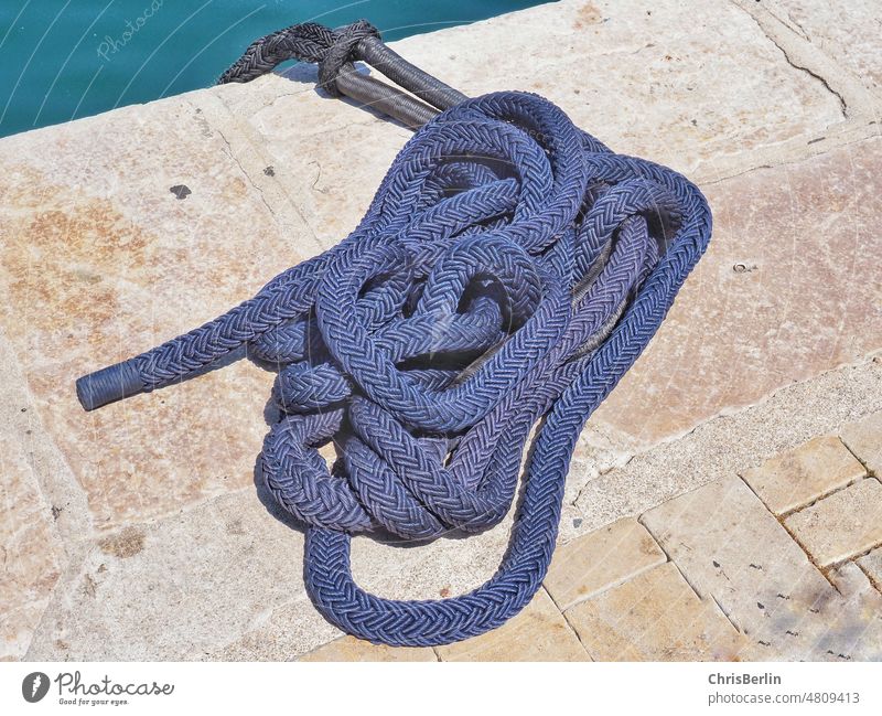 Blue ship jam on quay Strick rope Rope Colour photo Exterior shot Navigation Harbour Deserted Maritime Dew Detail mooring rope Close-up boat leash Knot