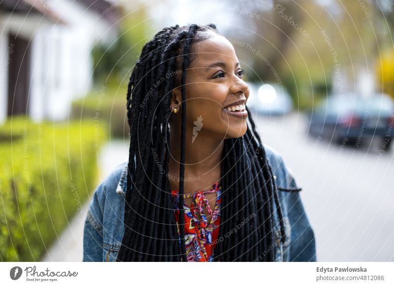 Portrait of a beautiful young woman in the city cool carefree confident day millennials dreadlocks enjoy authentic positive real people joyful toothy smile