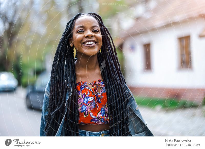 Portrait of a beautiful young woman in the city cool carefree confident day millennials dreadlocks enjoy authentic positive real people joyful toothy smile