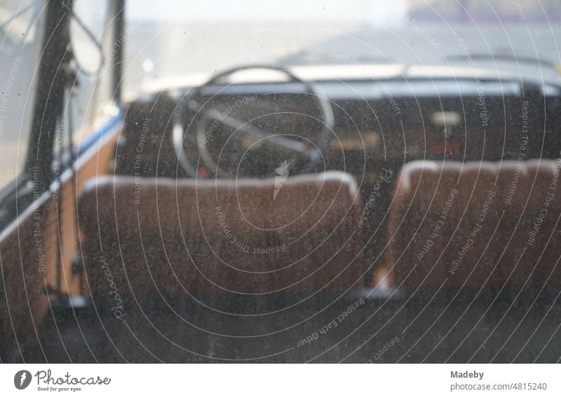 View through the dirty rear window on the interior and dashboard of a  German rear engine