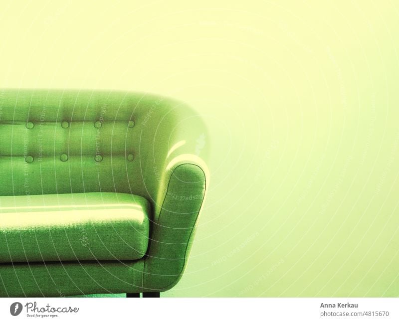 A sunlit green sofa stands in front of a greenish yellow wall Sofa Green Light Break seating furniture stylish coziness Living room Bright Colours Furniture