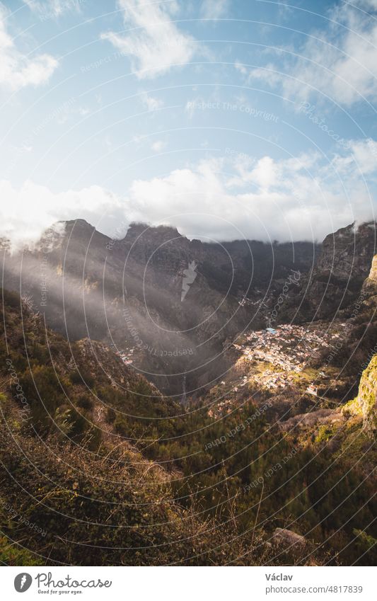 Very well-known tourist destination, Curral das freiras, a village nestled in the mountains with minimal sunlight. Aerial view of valley of nuns at sunset and peak of mountains in fog