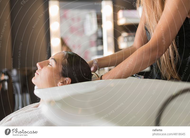 Side view of a hairdresser washing hair of a beautiful girl in hair salon. woman person client beauty head professional side view closeup female shampoo young
