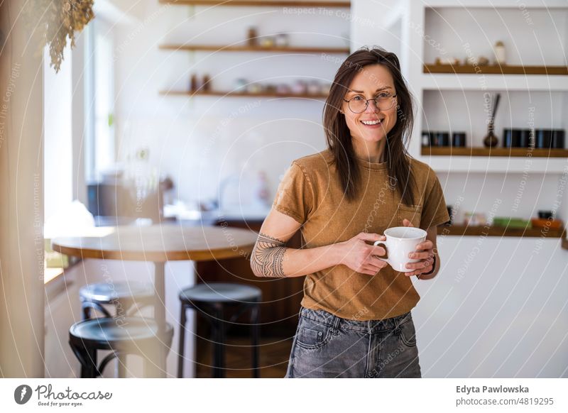 Portrait of a young woman standing in her home domestic life confidence indoors house people adult casual female Caucasian attractive beautiful tattoos one