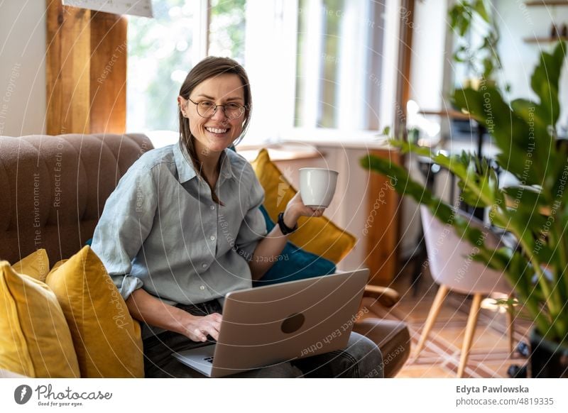 Young woman using a laptop at home domestic life confidence indoors house people young adult casual female Caucasian attractive beautiful tattoos one positive