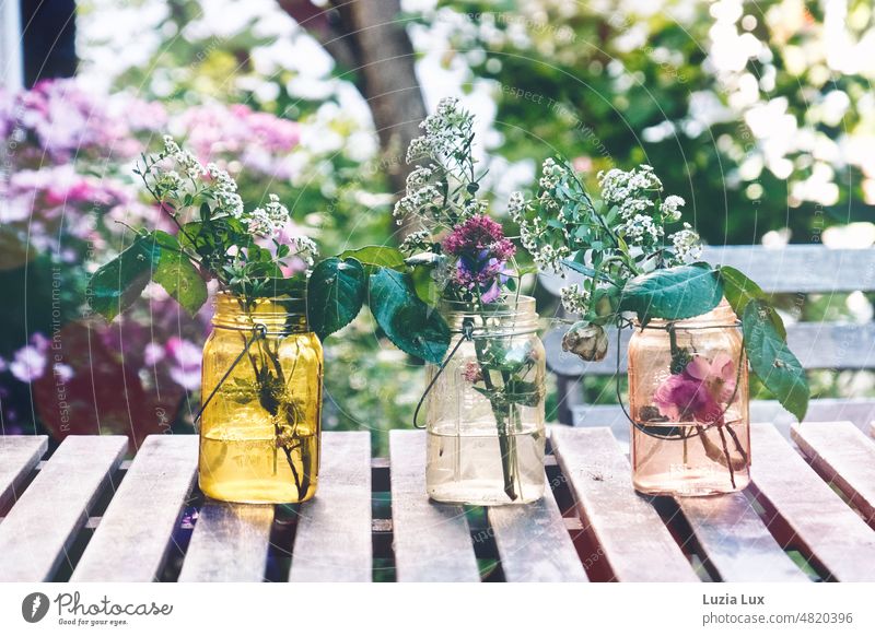 Evening mood in the garden, on the table three vases with lost flowers Garden evening mood Table out Delicate transient blossoms Spring Blossom Summer Flower