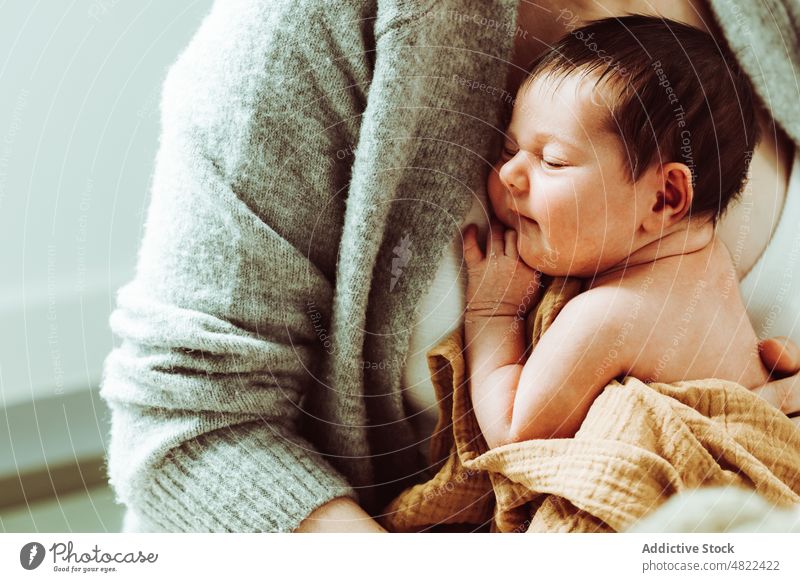 Crop mother hugging newborn baby in white studio woman love motherhood embrace care calm adorable infant childhood female young mom together parent bonding