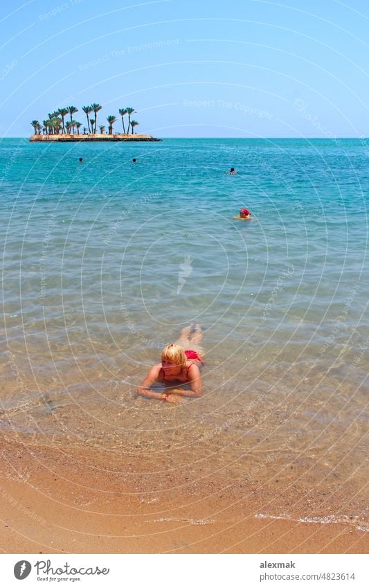Vaccinated tourists enjoying tropical islands. girl has a rest after vaccination vaccinated nice vacation young woman laying sea sand female child family