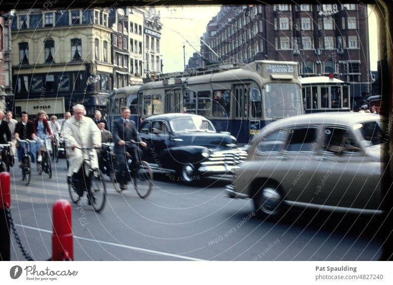 Bikes, Cars and Buses on the Street in Amsterdam, Holland in the 1950's Bicyclers bikes holland cityscape buses scenic Old town Building Architecture