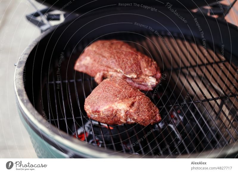 Two pieces of seasoned beef on a round green kamado grill to start grilling Barbecue (apparatus) Meat Eating food Kamado Kamado Grill Green Big Green Egg