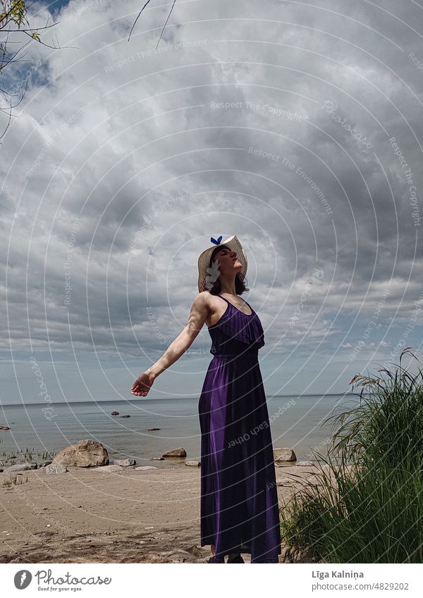 Woman at beach Movement Purple Fashion dancing Picturesque Dress summer hat Summer vacation Sky Beach Loneliness Scene tranquil Destination scenery Copy Space