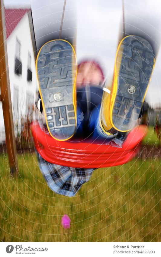 Child with rubber boots swinging in garden motion blur Garden Swing Playing Family Home family life Rubber boots blurred fun Infancy Joy To swing Playground