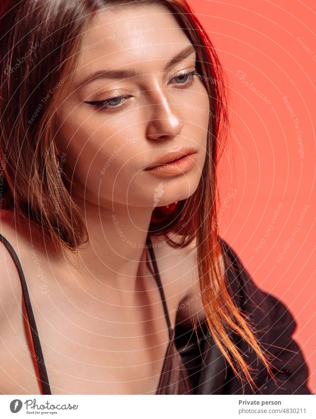 Portrait of a beautiful young woman with elegant makeup posing against a red background. Fashion and beauty. Female girl model portrait Mannequin ladies day