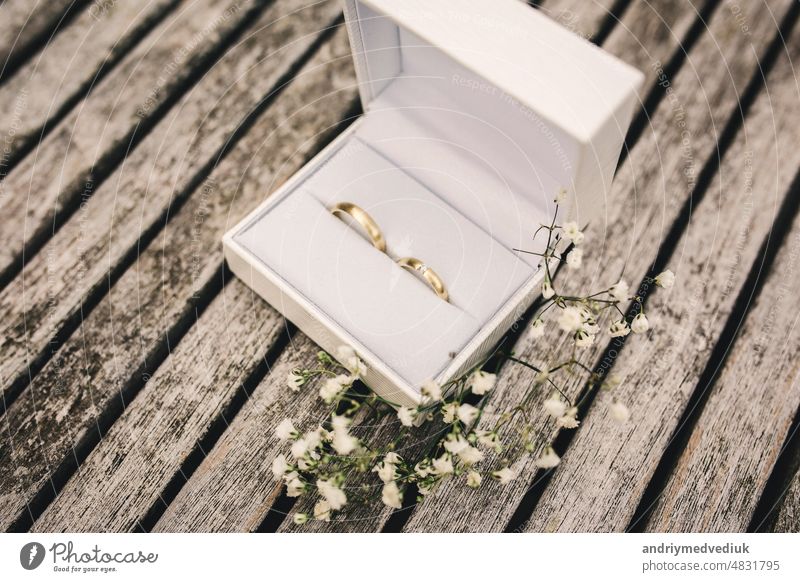 wedding rings in a box on the table. small flowers on a wooden table engagement diamond white jewelry isolated top background luxury jewellery gift silver