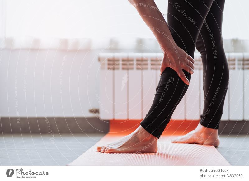 Crop barefoot pensioner stretching legs - a Royalty Free Stock