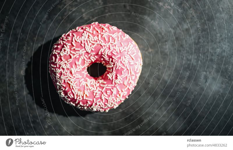 donut with pink glazed and sprinkles on a dark table assorted baked bakery breakfast cake calories chocolate color colorful delicious dessert donuts doughnut