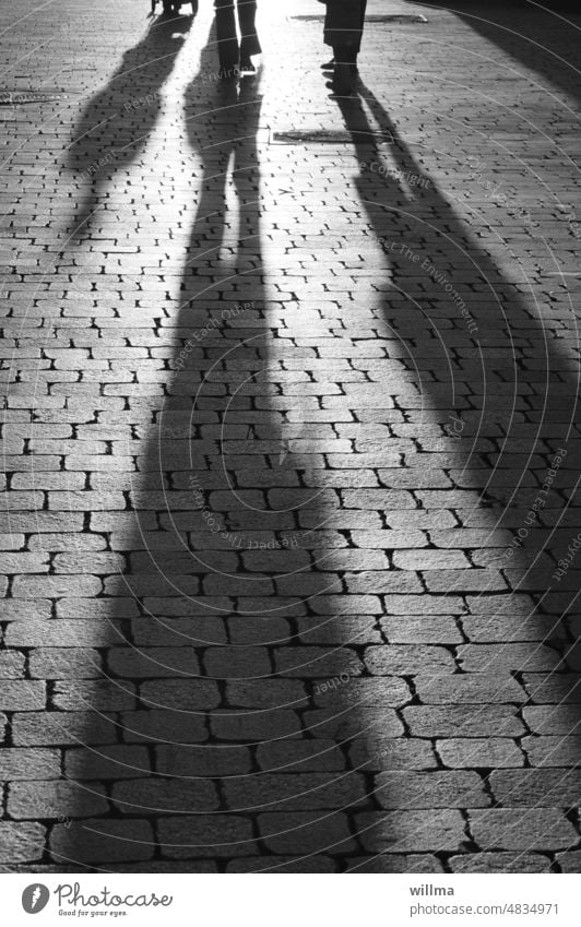 Light and shadow. Encounter and linger. Shadow people Legs Meetings Evening long shadows meetings People in the city stroll City walk End of the day persons
