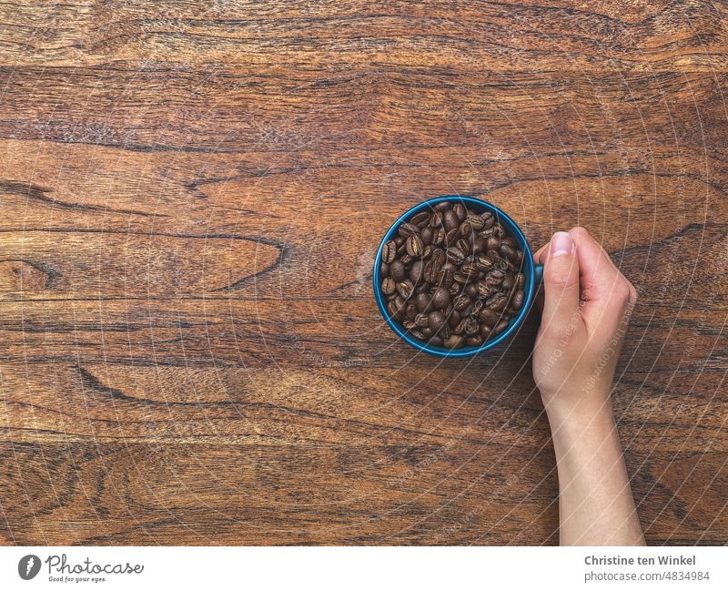 Now a strong coffee ... Coffee cup Coffee bean Coffee beans in a cup Cup Tabletop Wooden table top Hand arm Hot toast Lifestyle Beans roasted Brown