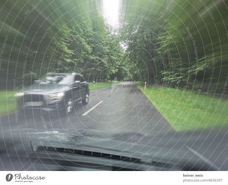 Driving a car through the green forest on a country road in rainy weather and oncoming traffic by other cars Motor vehicle Car Rain Rainy weather Forest Green