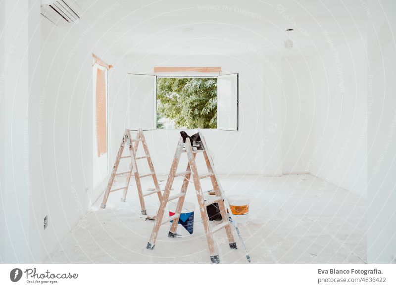 ladders and painter tools on white room at construction site. Painting walls. Home improvement, renovation works home house colors interior roller grey painting