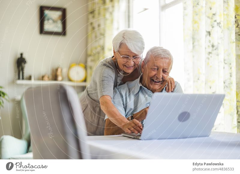 Happy senior couple using laptop at home senior adult older aged portrait person casual leisure lifestyle pensioner caucasian retired people mature retirement
