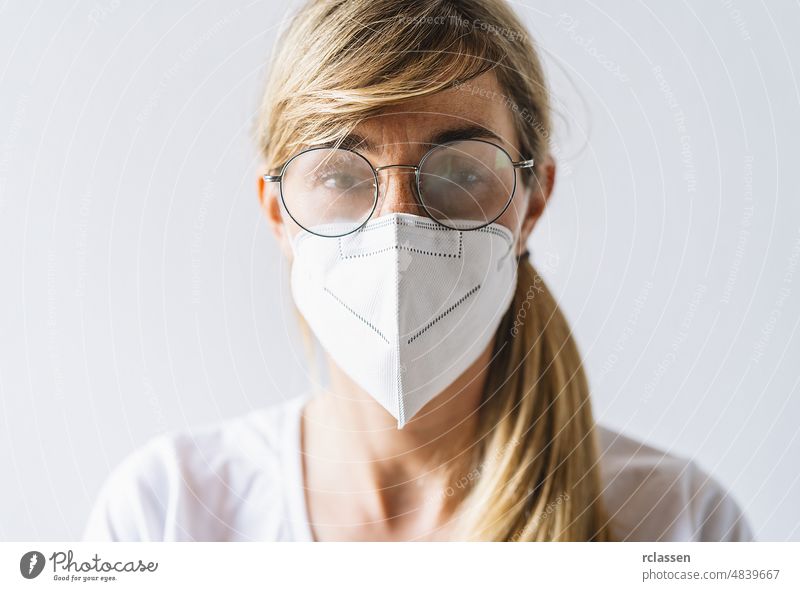 Woman wearing N95 FFP2 an anti virus protection mask and glasses are fogged up to prevent others from corona COVID-19 and SARS cov 2 infection covid woman