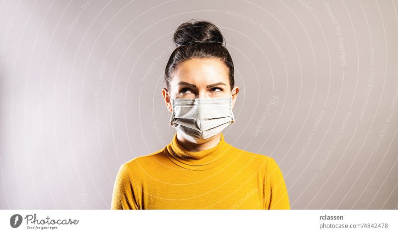 Woman with anti virus protection mask to prevent others from corona COVID-19 and SARS cov 2 infection  looking up over coronavirus pandemic cov-2 covid covid 19