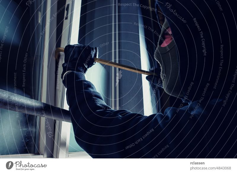 burglar using crowbar to break into a victim's house at night police apartment steal white robbery tool housebreaker concept illegal male insurance glove black