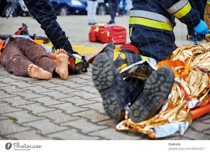 Rescuers provide first aid to the victim during car road accident corpse body dead police firefighter rescuer bag black caution killed motorway tape assistance