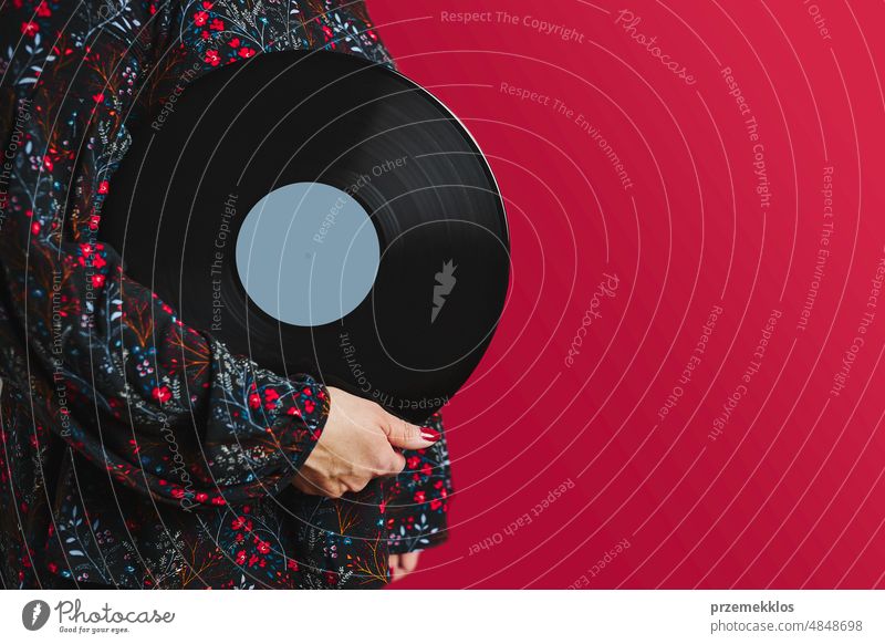 Woman holding vinyl record. Music passion. Listening to music from analog record. Playing music from analog disk. Enjoying music from old collection. Retro and vintage. Stereo audio. Analog sound