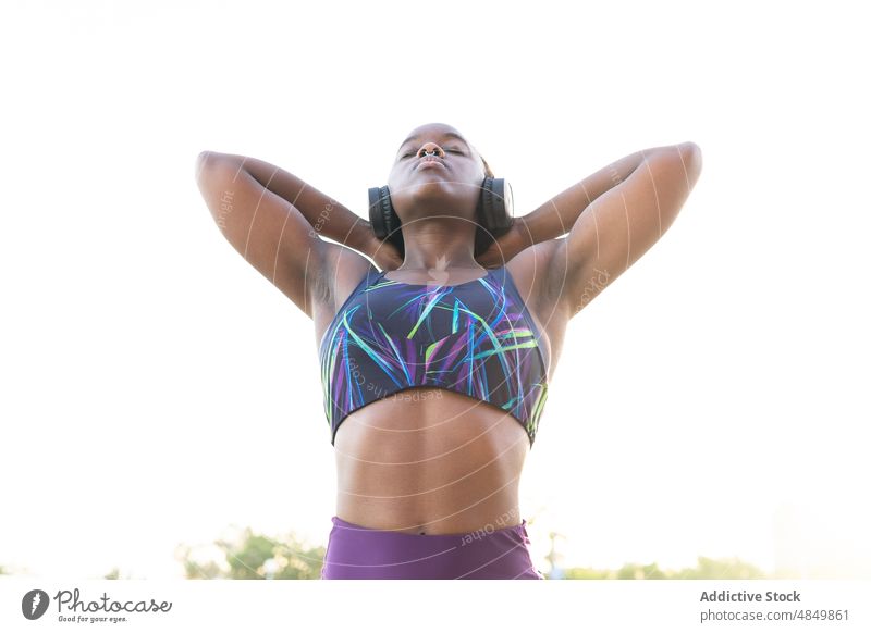 Athletic black woman doing exercises on street - a Royalty Free